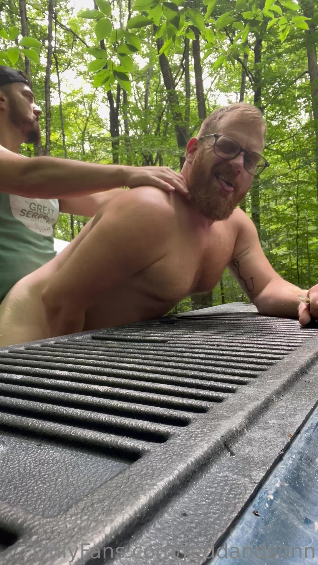 "American" Is Laying Some Pipe On A Tailgate, While Other Men Watch